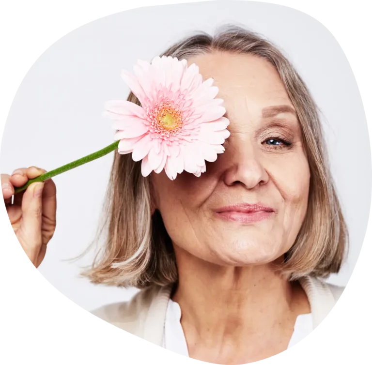 Praxis für Physiotherapie Hamburg, lächelnde Frau hält Blume vor ein Auge